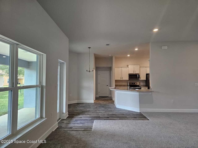 kitchen with appliances with stainless steel finishes, baseboards, white cabinets, and a healthy amount of sunlight