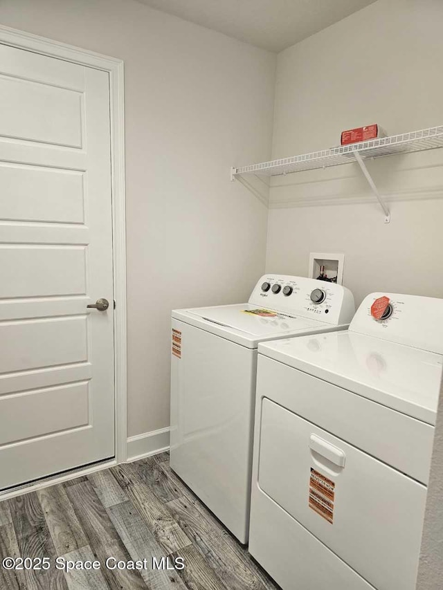laundry room with light wood-style flooring, laundry area, washing machine and clothes dryer, and baseboards