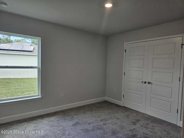 unfurnished bedroom featuring a closet, baseboards, and carpet