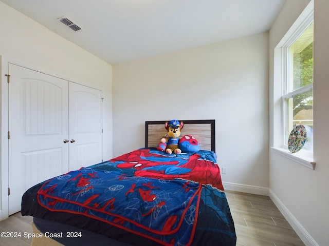 bedroom with a closet and light hardwood / wood-style floors