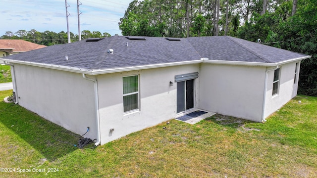 rear view of property with a lawn