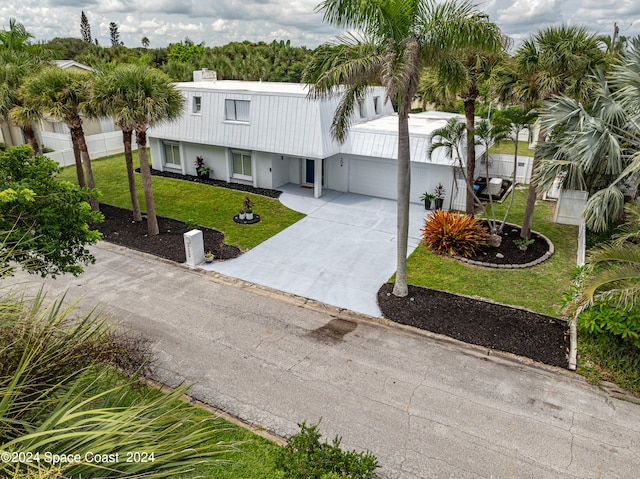 view of front facade featuring a front yard, a garage, and a carport