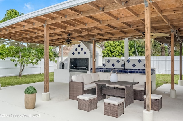 view of patio / terrace featuring an outdoor living space with a fireplace and ceiling fan