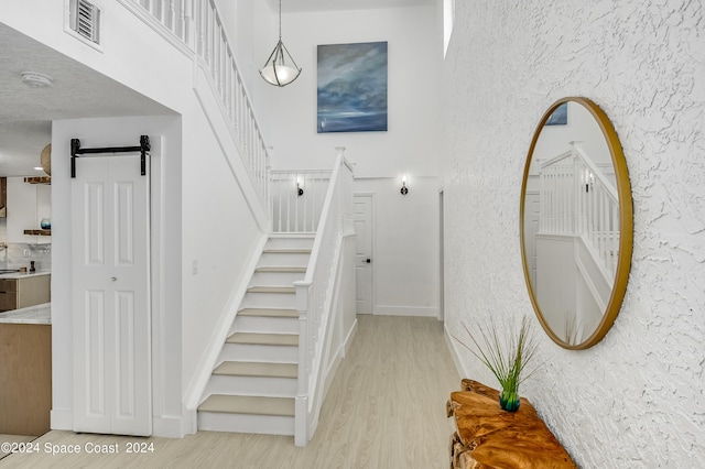 stairs featuring a textured ceiling, hardwood / wood-style floors, and a barn door