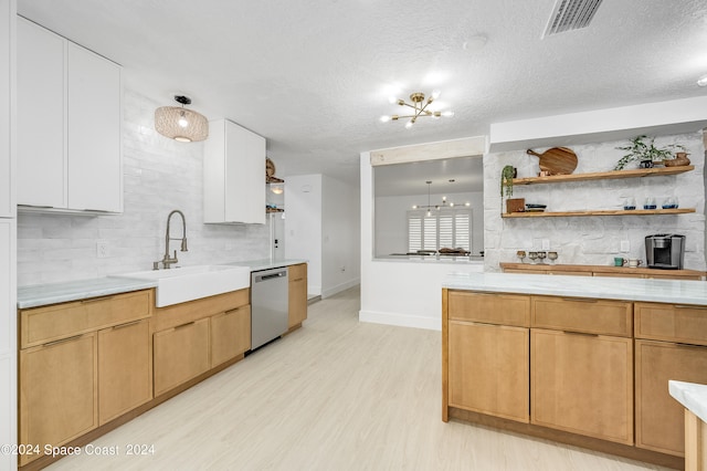 kitchen with white cabinetry, an inviting chandelier, light hardwood / wood-style flooring, stainless steel dishwasher, and sink