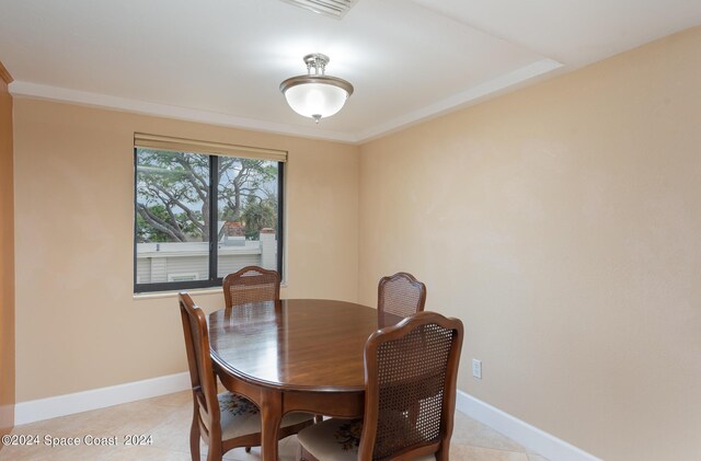 tiled dining area featuring crown molding