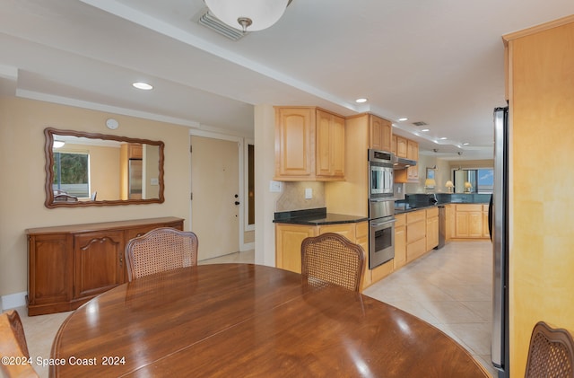 kitchen with light brown cabinetry, light tile patterned floors, and stainless steel dishwasher