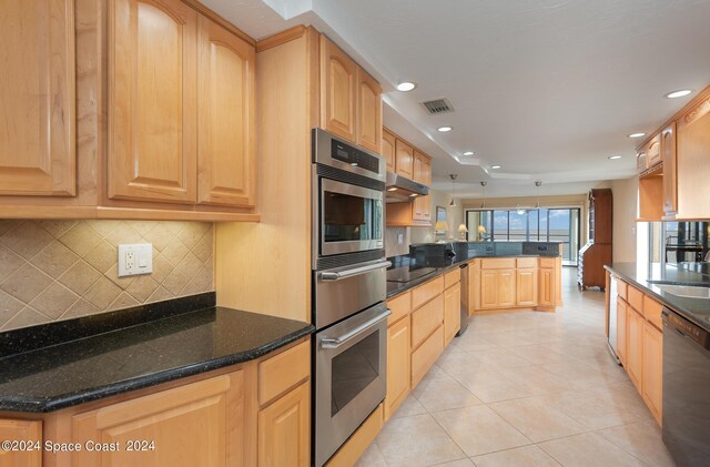 kitchen with oven, black dishwasher, and dark stone countertops