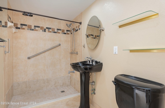 bathroom with tiled shower and tile patterned flooring