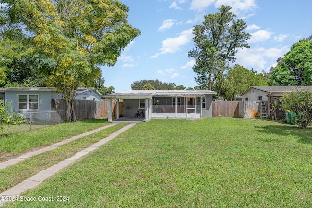 rear view of house featuring a yard and a carport