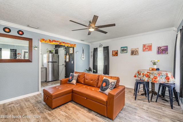 living room with ceiling fan, a textured ceiling, crown molding, and light hardwood / wood-style flooring