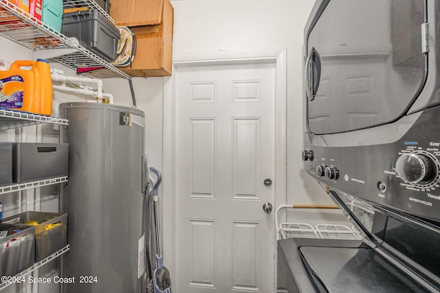 washroom featuring stacked washer / dryer and water heater