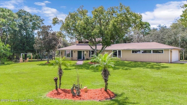 back of house featuring a lawn and a garage