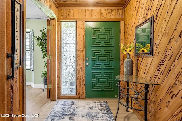 foyer entrance featuring wood-type flooring and wooden walls