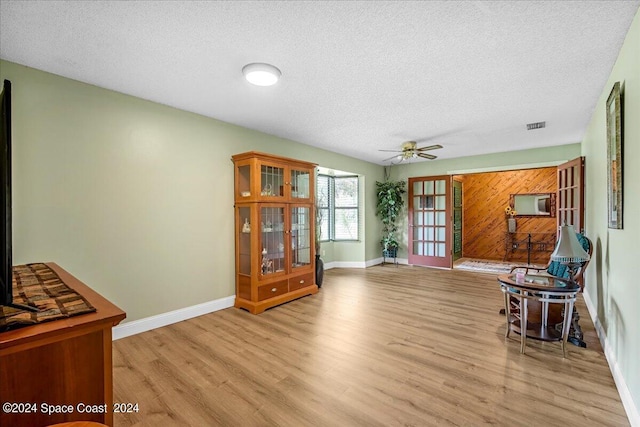 sitting room featuring a textured ceiling, ceiling fan, and light hardwood / wood-style floors