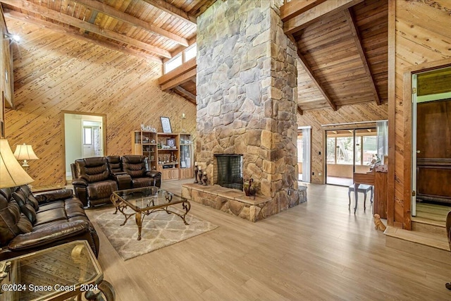 unfurnished living room with wood walls, a fireplace, wood ceiling, high vaulted ceiling, and hardwood / wood-style flooring