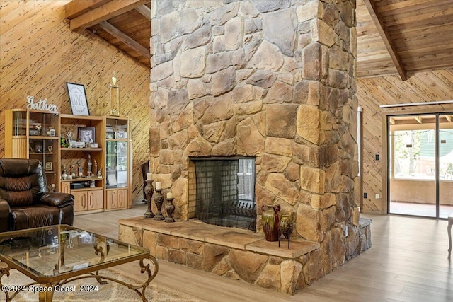 unfurnished living room featuring wood walls, a fireplace, light hardwood / wood-style floors, and wooden ceiling