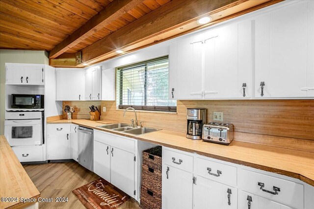 kitchen with oven, white cabinetry, and stainless steel dishwasher