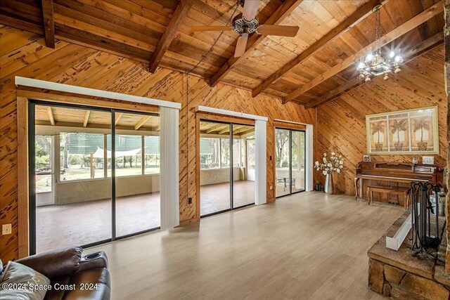 living room featuring ceiling fan with notable chandelier, lofted ceiling with beams, and light hardwood / wood-style floors