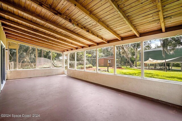 unfurnished sunroom featuring wood ceiling and beam ceiling