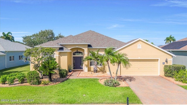 view of front of property with a front yard and a garage