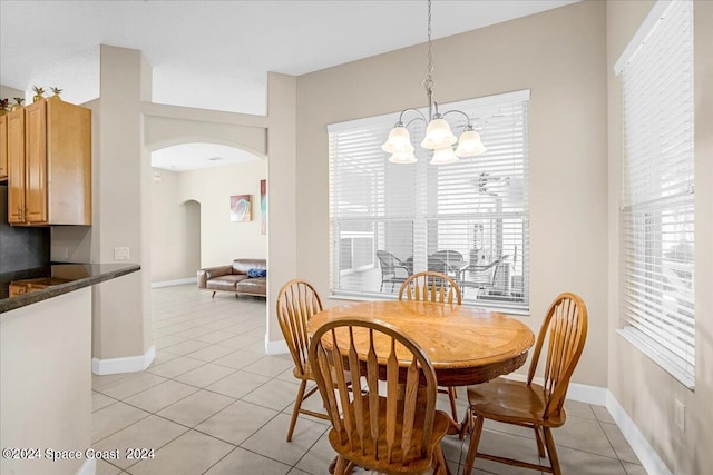 dining area featuring light tile patterned floors and a notable chandelier