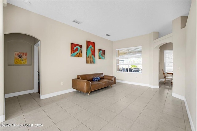 living area featuring a textured ceiling and light tile patterned floors