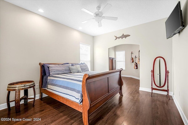 bedroom featuring a textured ceiling, ceiling fan, and dark hardwood / wood-style floors