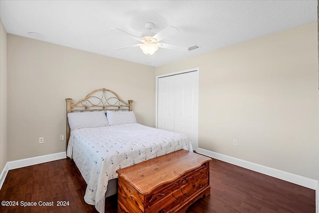 bedroom featuring dark hardwood / wood-style floors, a textured ceiling, ceiling fan, and a closet