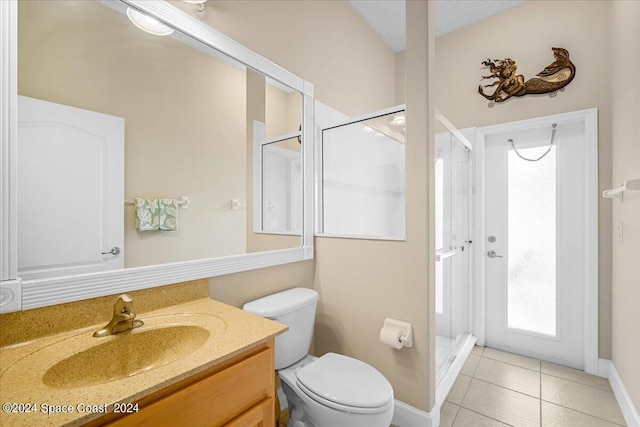 bathroom with vanity, a shower with shower door, tile patterned floors, and toilet