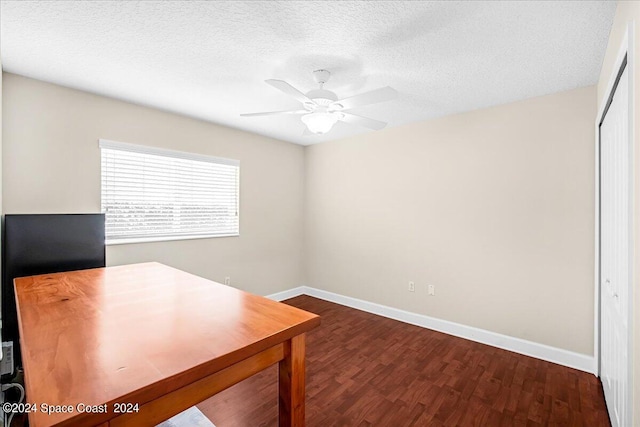 unfurnished office featuring ceiling fan, dark hardwood / wood-style floors, and a textured ceiling