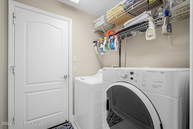 clothes washing area featuring a textured ceiling and washer and dryer