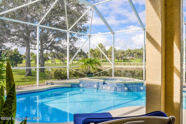 view of pool featuring a lanai and an in ground hot tub