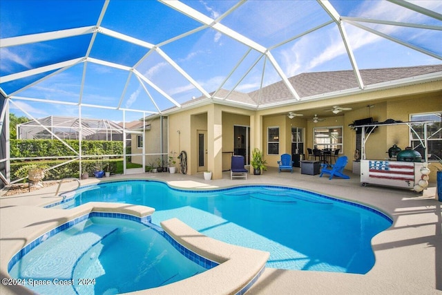 view of pool with ceiling fan, a patio area, glass enclosure, and an in ground hot tub