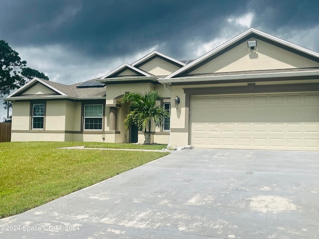 view of front of house featuring a garage and a front lawn