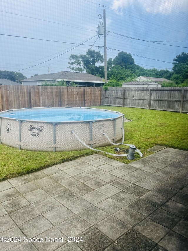 view of swimming pool featuring a yard and a patio area