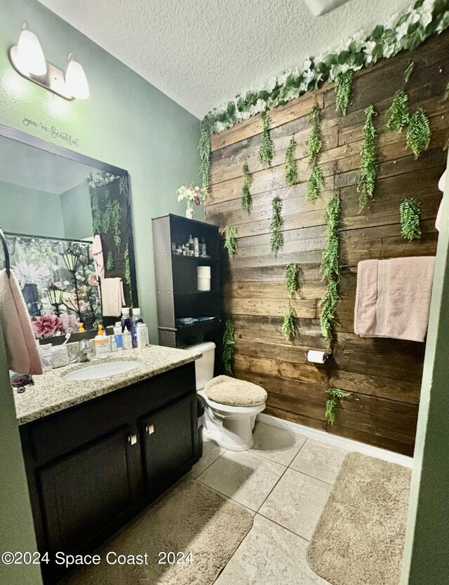 bathroom featuring a textured ceiling, vanity, toilet, and tile patterned flooring