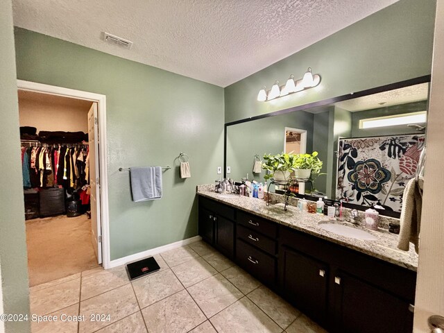 bathroom featuring tile patterned flooring, a textured ceiling, and vanity