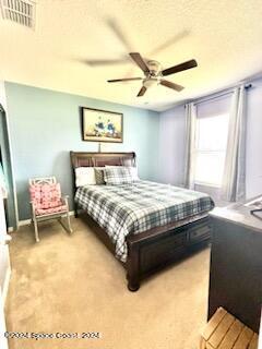 bedroom featuring ceiling fan, a textured ceiling, and carpet floors