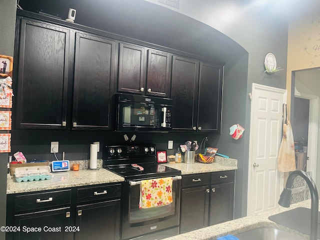 kitchen with stainless steel range with electric stovetop, light stone counters, and sink