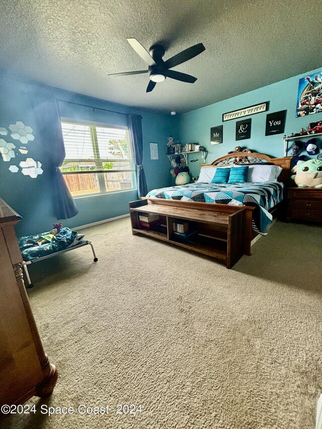 bedroom featuring ceiling fan, carpet, and a textured ceiling