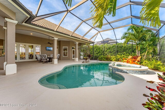 view of pool with a patio area, glass enclosure, french doors, ceiling fan, and an in ground hot tub