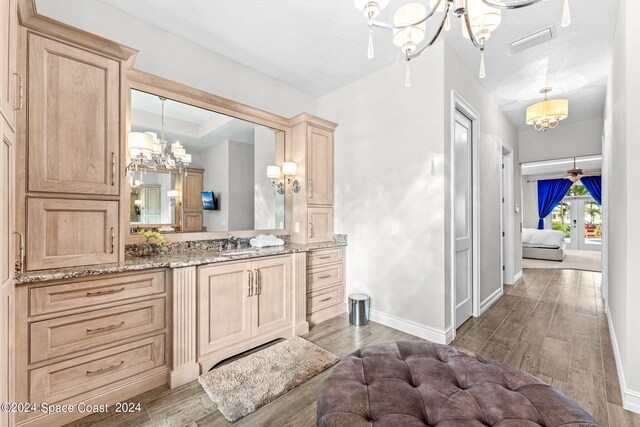 bathroom featuring a textured ceiling, vanity, a notable chandelier, and wood-type flooring