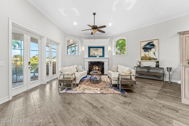 living room with hardwood / wood-style floors, ceiling fan, a wealth of natural light, and crown molding