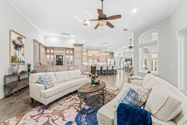 living room featuring ceiling fan, ornamental molding, and hardwood / wood-style flooring