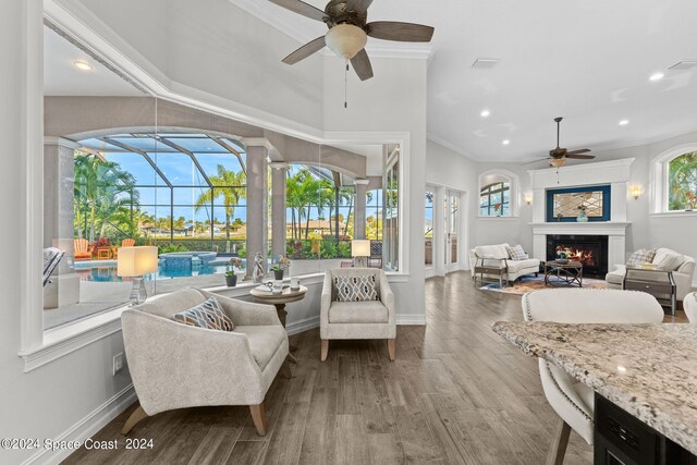 living room with ceiling fan, hardwood / wood-style flooring, and crown molding