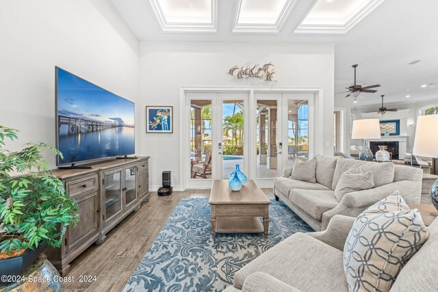 living room featuring crown molding, french doors, wood-type flooring, and ceiling fan