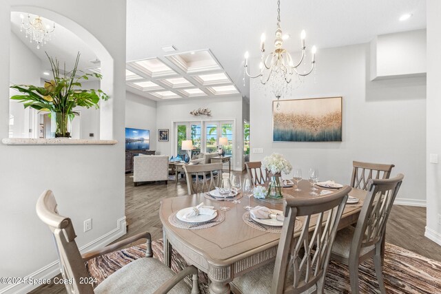 dining space with a chandelier, coffered ceiling, wood-type flooring, and beam ceiling