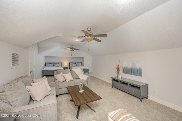 carpeted living room with ceiling fan, vaulted ceiling, and a textured ceiling