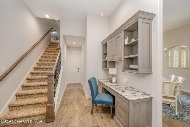 kitchen featuring light hardwood / wood-style flooring, light stone counters, and gray cabinetry